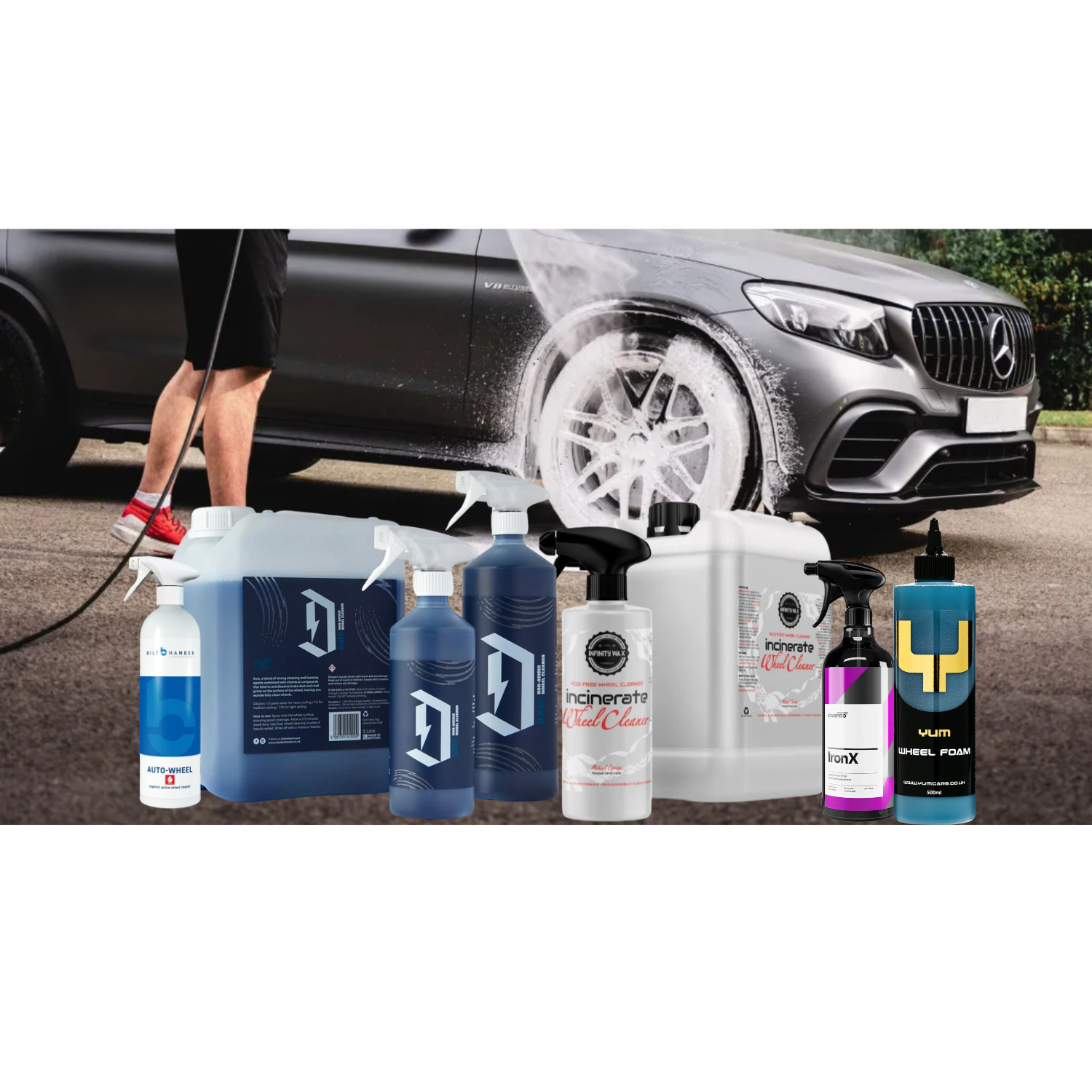 Bilt Hamber Auto Wheel Cleaner, CarPro IronX Alloy Cleaner, Infinity Wax Incinerate, Duel Axis Acid-Free Wheel Cleaner, and YumCars Wheel Foam placed in front of an alloy wheel being sprayed with foam