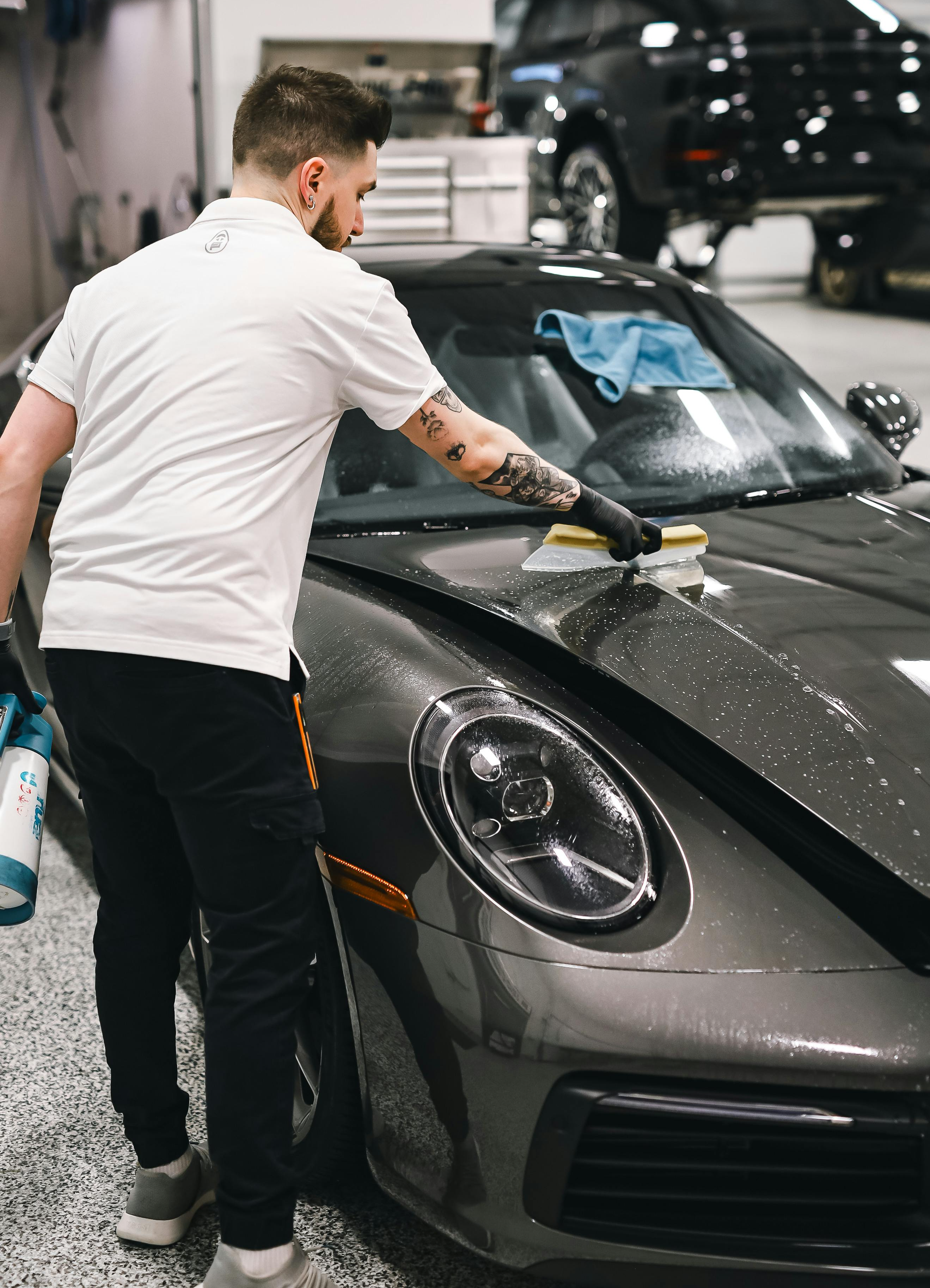 A man wiping down his car’s interior, showcasing proper cleaning techniques and car care tips from Infinity Wax for maintaining a pristine vehicle.