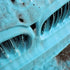 Blue coloured foam clinging to a front grille, close up