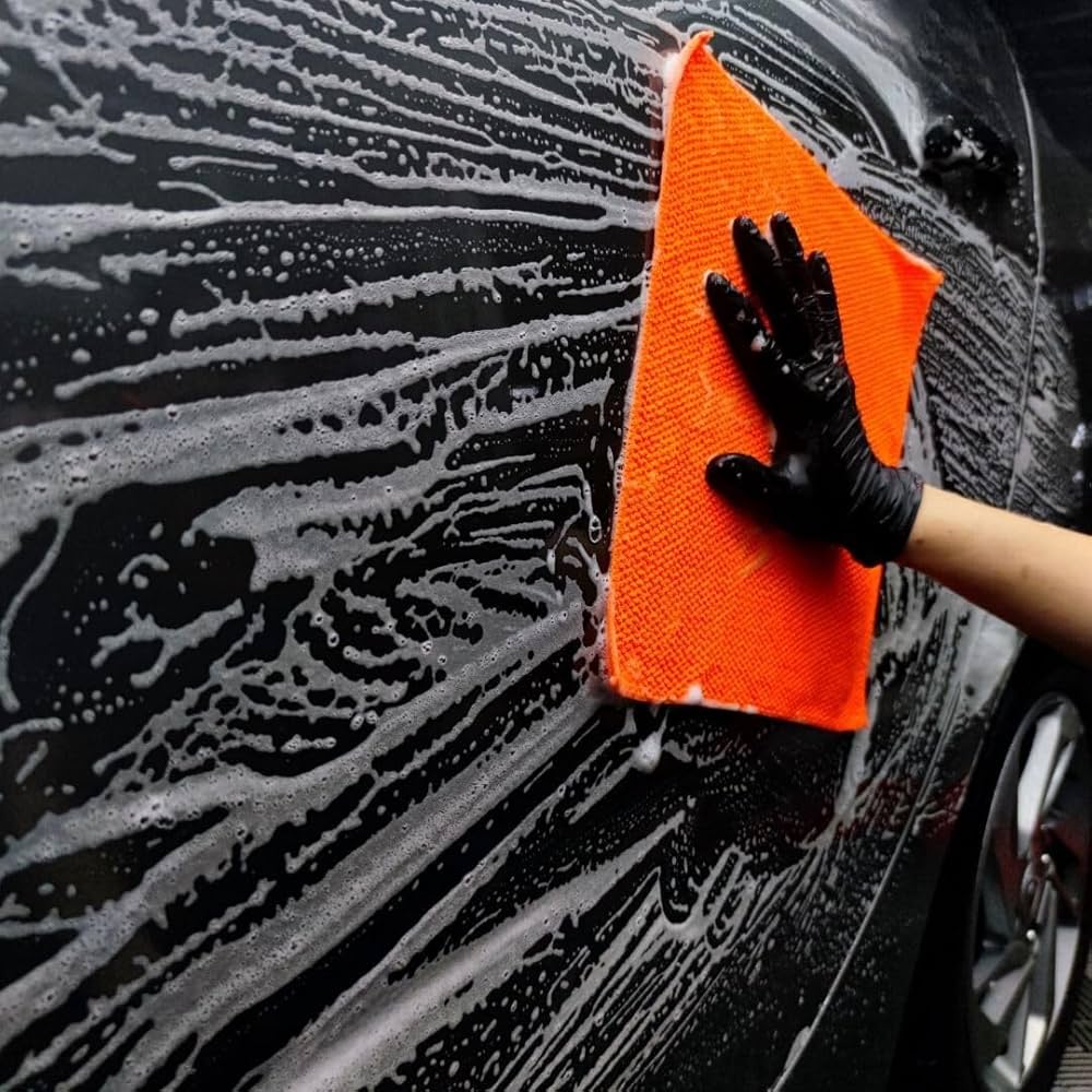CarPro PolyShave towel being used on a foam-covered car panel